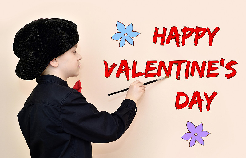 Young,painter,with,black,shirt,and,cap,writing,with,the,paint,brush,HAPPY,VALENTINE’S,DAY,message,on,the,wall