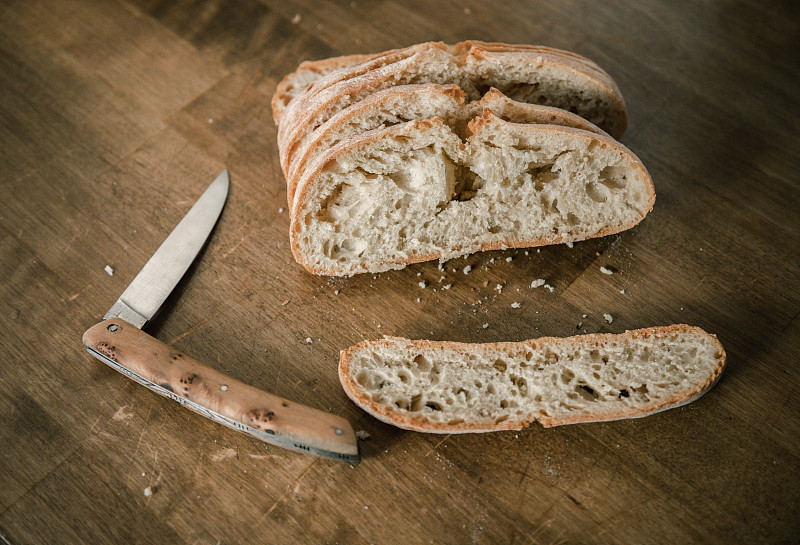 Pain,de,campagne,tanché,et,son,couteau,sur,une,table,de,travail