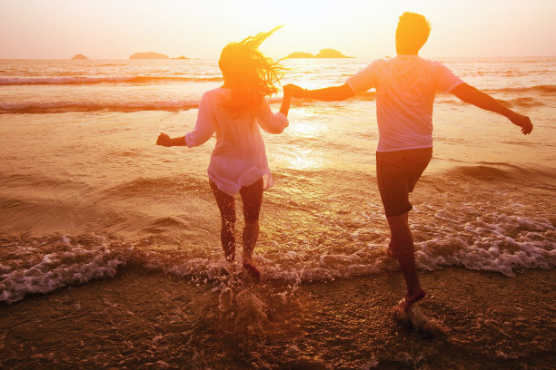 情侣沿着海滩跑