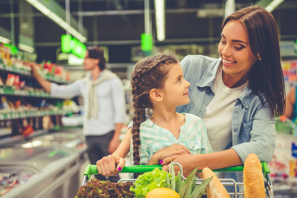 微笑的母亲和女儿在逛超市