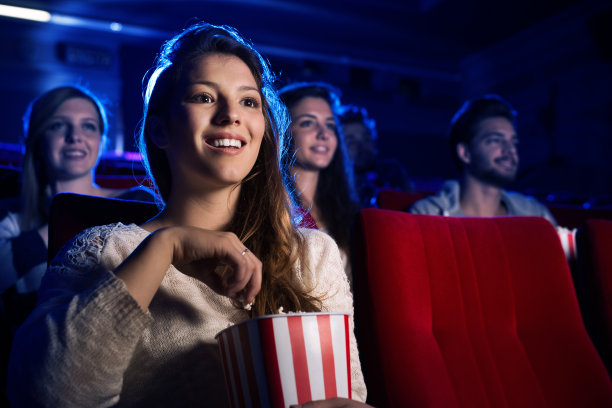 年轻的女人在电影院看电影