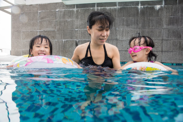 妈妈训练孩子们在游泳池游泳