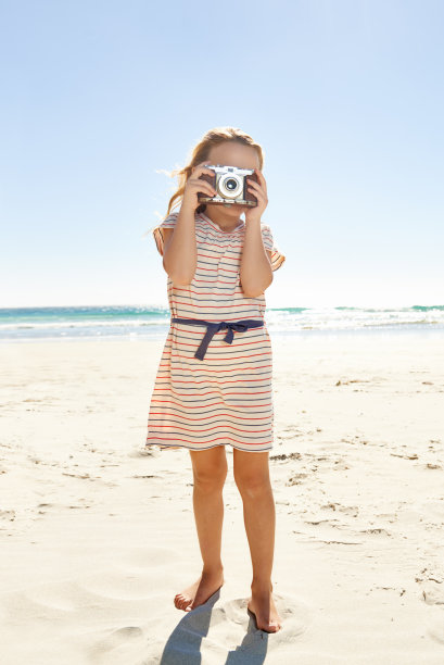 沙滩上拍照的少女
