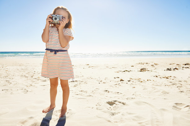 沙滩上拍照的少女