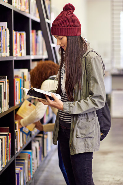 漂亮的学生在大学图书馆里看书