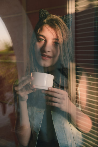 透过窗户看咖啡杯女人的肖像