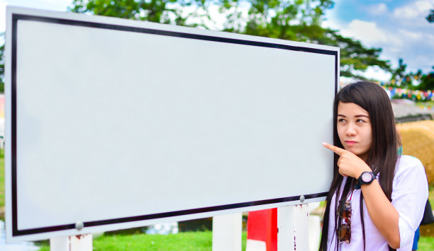 年轻的亚洲女性展示并手持空白的白色广告牌