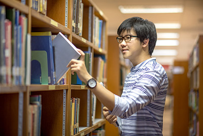 在图书馆挑选书的大学生