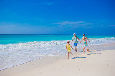 快乐家庭在沙滩上奔跑