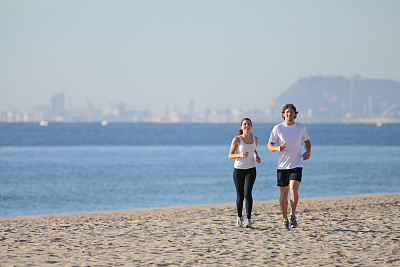 情侣沿着海滩跑