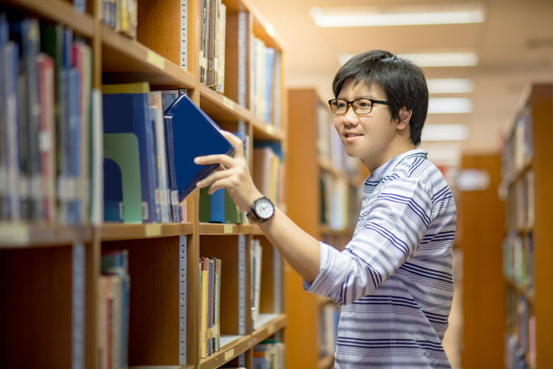 在图书馆挑选书的大学生