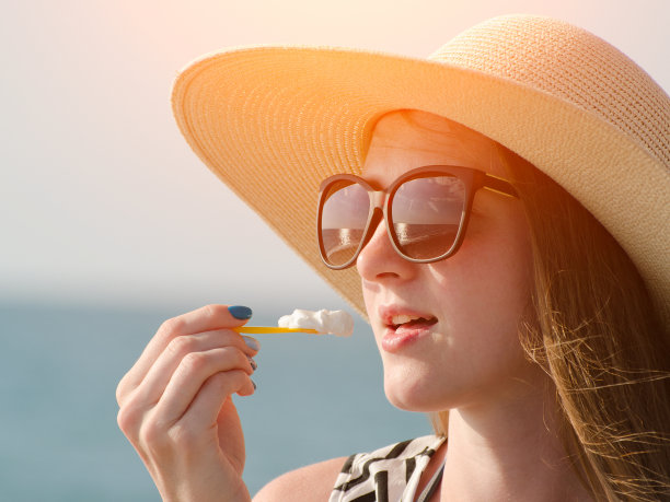 夏天帽子上的女人吃冰淇淋