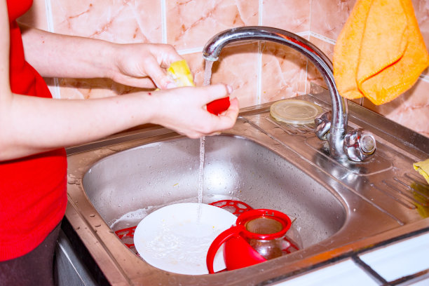 妇女戴手套洗餐具