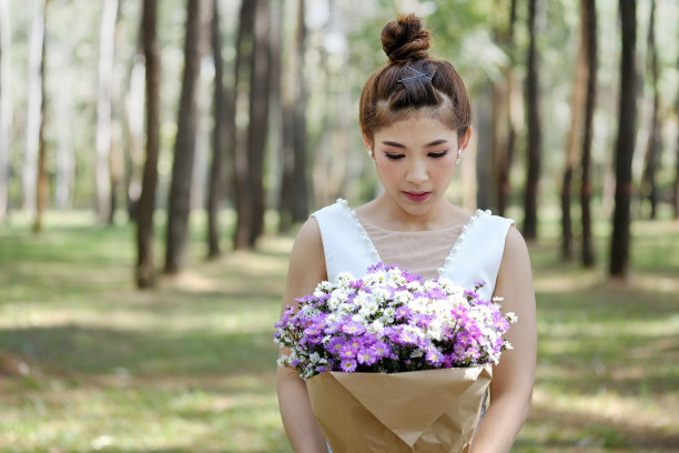 穿着婚纱拿着一束花的新娘