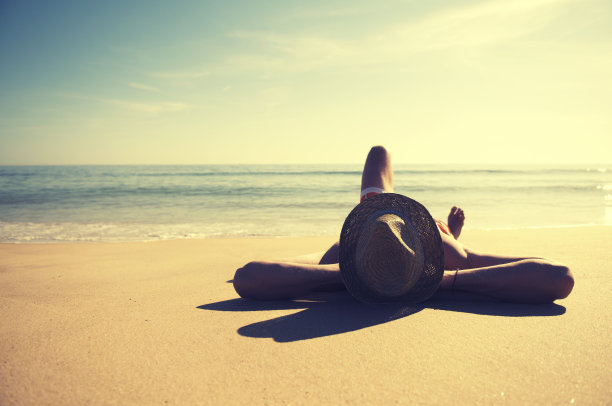 躺在沙滩晒太阳，夏天人们