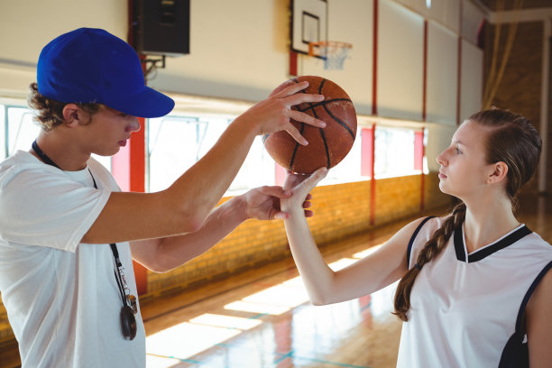 教练站在篮球场上训练十几岁的男孩