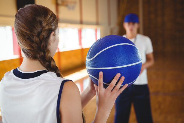 教练站在篮球场上训练十几岁的男孩