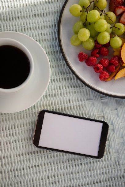 咖啡厅的咖啡杯和桌上水果手机