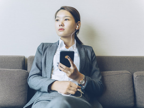 女人坐在家里的沙发上透过窗户看