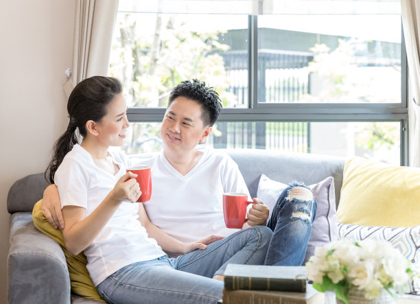 女人坐在家里的沙发上透过窗户看