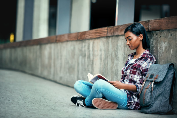 盘腿坐在地上看书的女人
