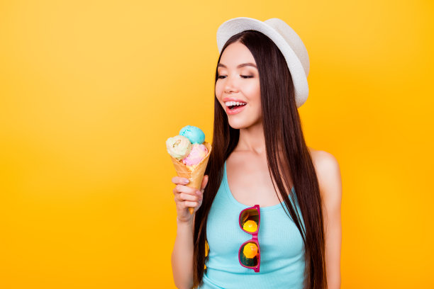 夏天帽子上的女人吃冰淇淋