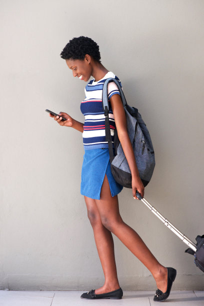 年轻女子拉着行李使用手机