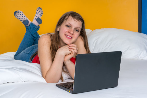 年轻女子在床上使用电脑