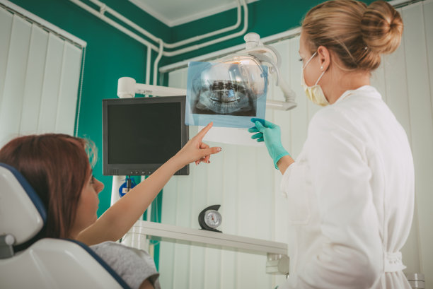 牙医在牙科诊所展示x光片