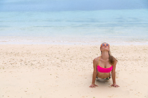 在海滩上做瑜伽的漂亮女人