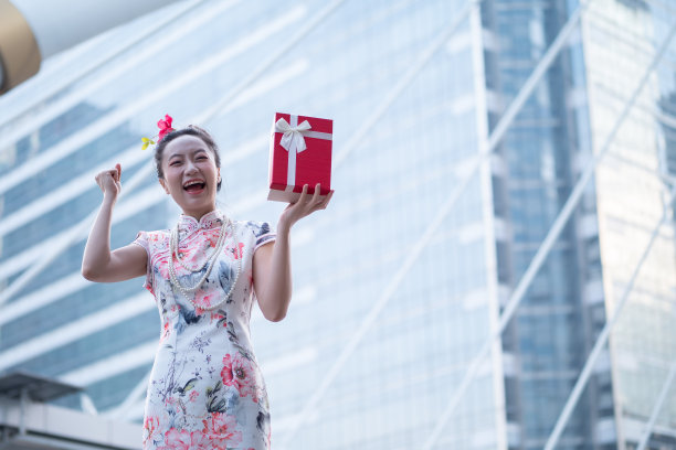 年轻的亚洲女子持有中国新年礼盒