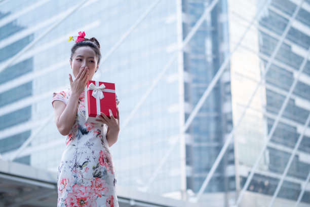 年轻的亚洲女子持有中国新年礼盒