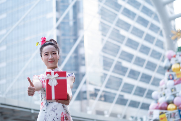 年轻的亚洲女子持有中国新年礼盒