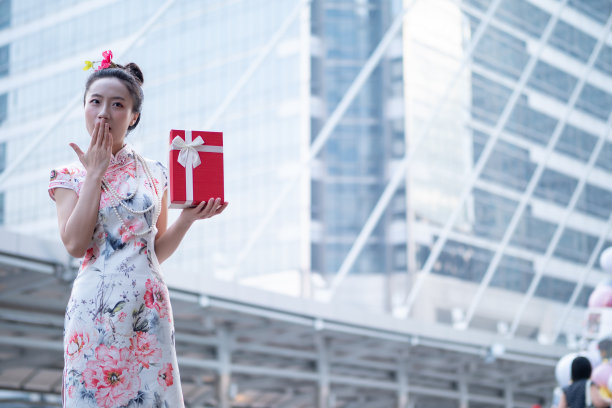 年轻的亚洲女子持有中国新年礼盒