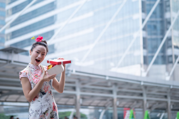 年轻的亚洲女子持有中国新年礼盒