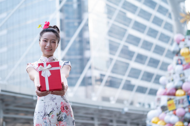 年轻的亚洲女子持有中国新年礼盒