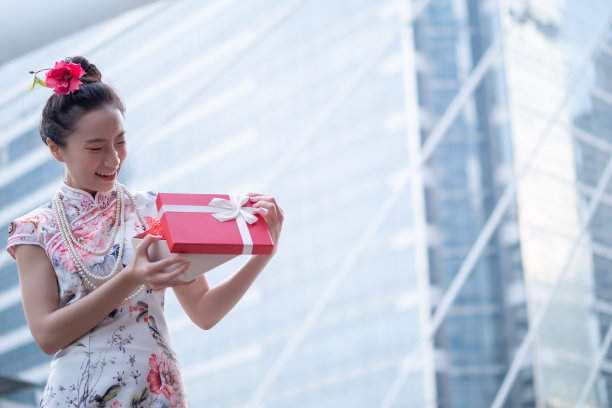 年轻的亚洲女子持有中国新年礼盒