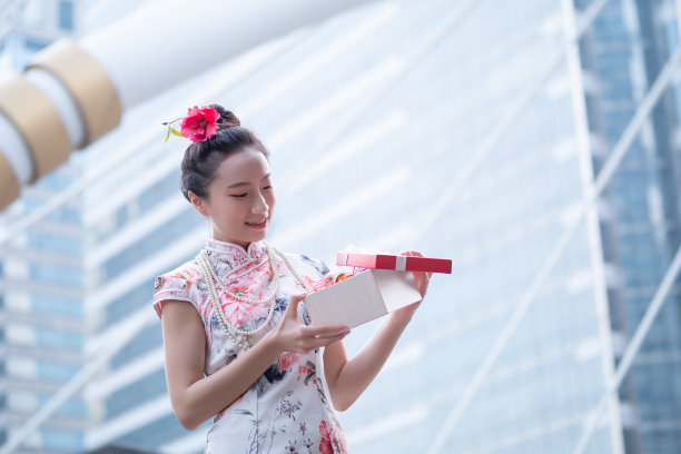 年轻的亚洲女子持有中国新年礼盒