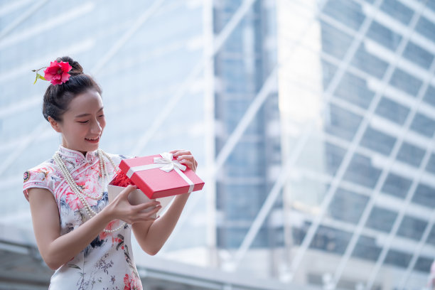 年轻的亚洲女子持有中国新年礼盒