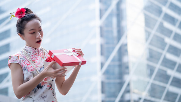 年轻的亚洲女子持有中国新年礼盒