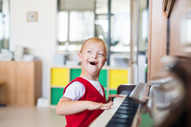 坐在教室里弹钢琴的小男孩