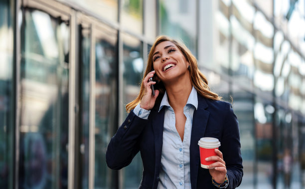 喝着咖啡使用手机的商务女人
