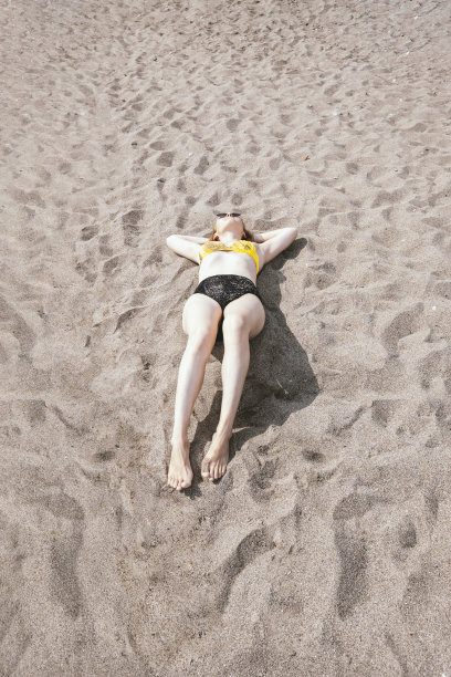 躺在沙滩晒太阳，夏天人们