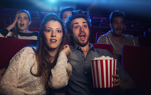 年轻的女人在电影院看电影