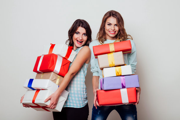 微笑的两个女人拿着圣诞礼物盒