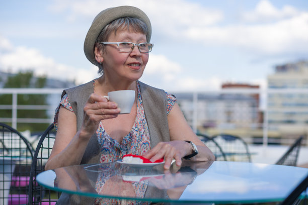 坐在咖啡馆喝咖啡的老年妇女