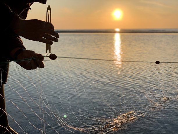 夕阳下海边捕鱼