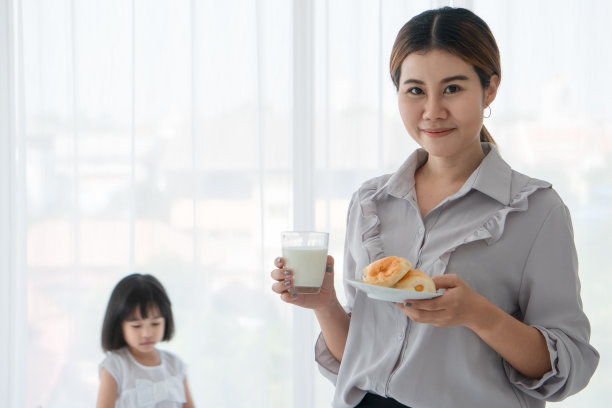 年轻女子在厨房喝牛奶