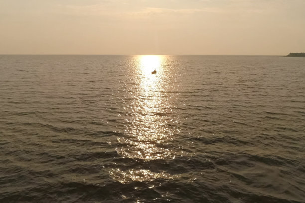 在阳光下的大海中航行的渔船