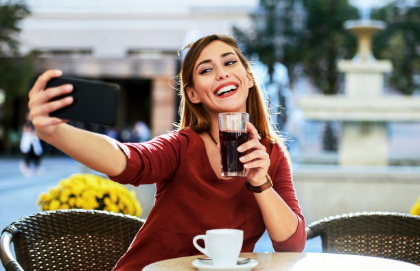 喝着咖啡使用手机的商务女人